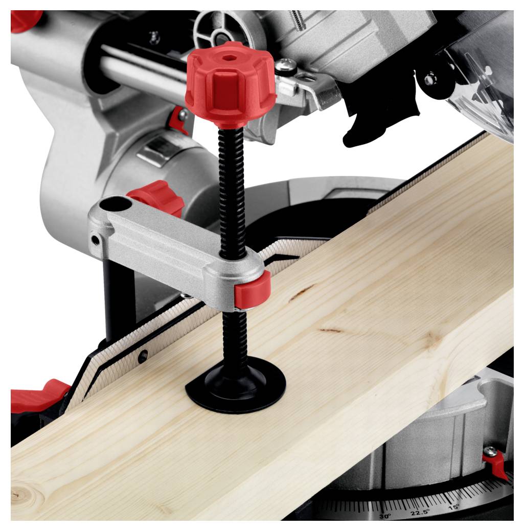 Piła ukośnica tnąca kawałek drewna, zabezpieczony zaciskiem.