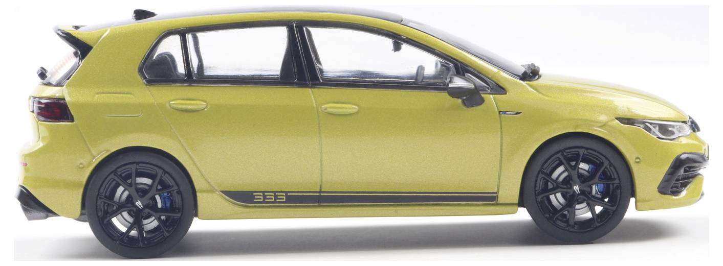 Widok z boku żółtego hatchbacka z paskiem i numerem '333' na boku, z czarnymi kołami i niebieskimi zaciskami hamulcowymi.