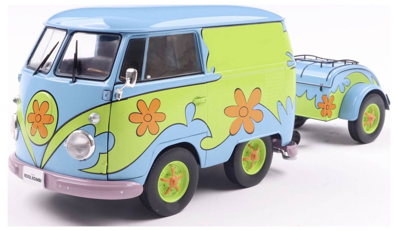 Kolorowy van ozdobiony pomarańczowymi kwiatami i zielonymi wirkami, ciągnący pasującą przyczepę, przypominający styl retro.