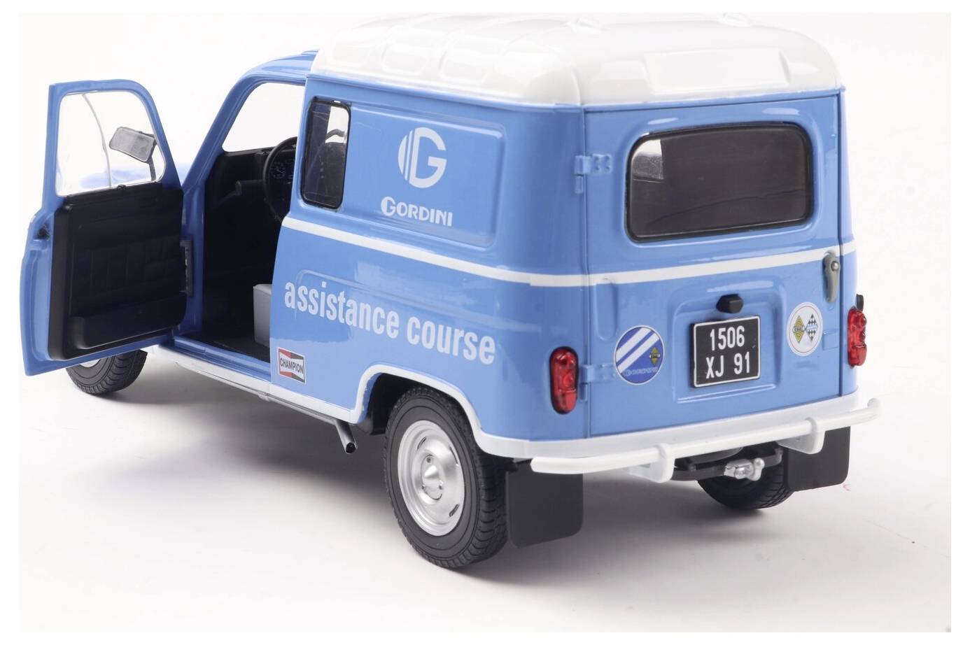 Niebiesko-biały van z oznakowaniem 'Gordini assistance course' z otwartymi drzwiami, sugerujący gotowość do świadczenia usług lub transportu.
