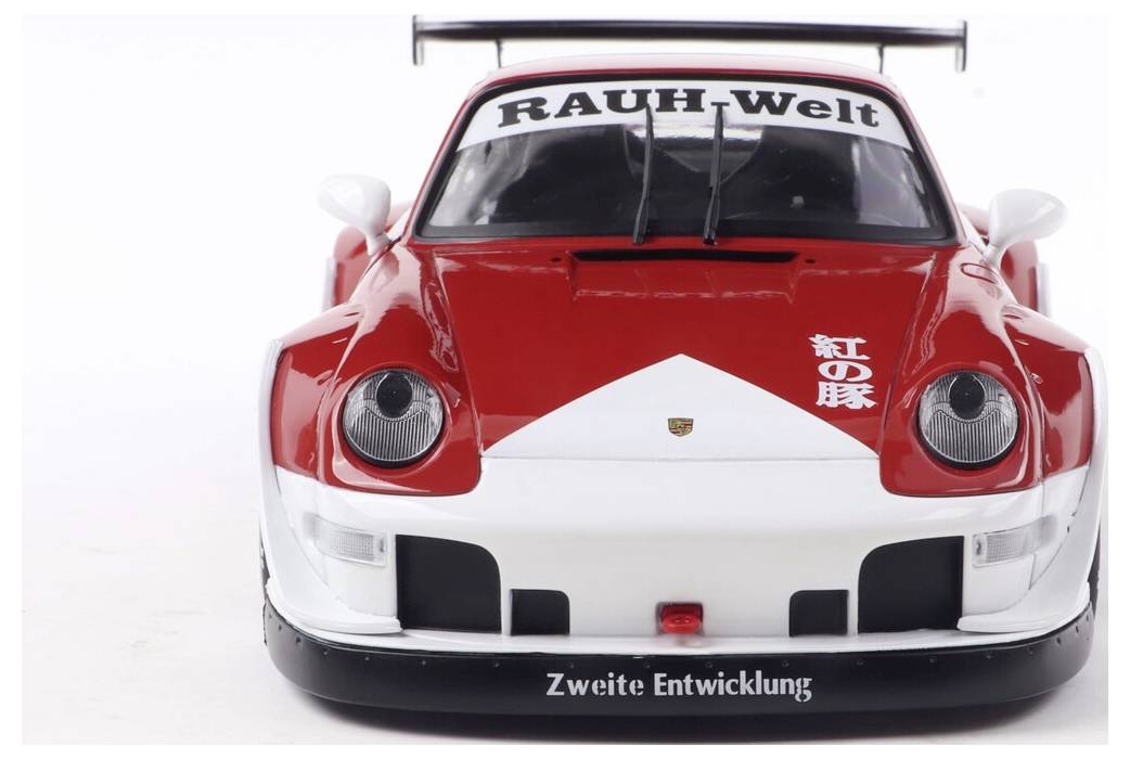 Czerwono-biały model samochodu sportowego z napisem 'RAUH-Welt' na przedniej szybie i japońskim tekstem na masce, prezentujący jego odważny przedni design.