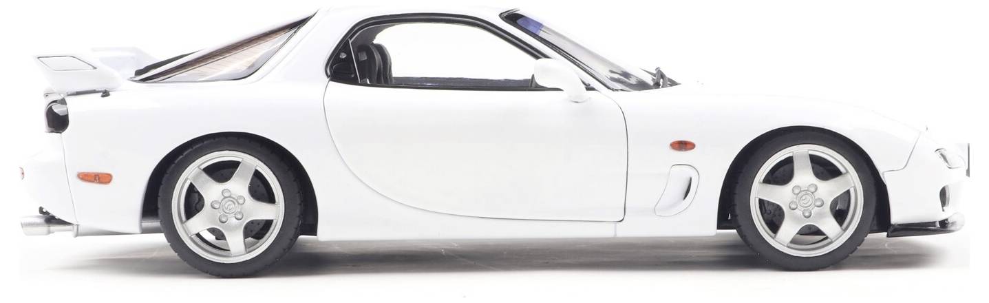 Biały samochód sportowy widziany z boku, prezentujący elegancki design i felgi ze stopu metali, podkreślający aerodynamiczny kształt i styl pojazdu.