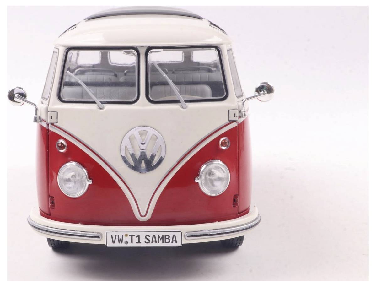 Czerwono-biały zabytkowy model autobusu Volkswagen Samba sfotografowany od przodu, z klasyczną emblemat VW i tablicą rejestracyjną z napisem 'VW T1 SAMBA'.