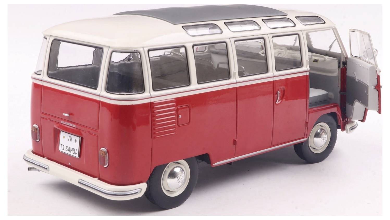 Zabytkowy, czerwono-biały van z podniesionym dachem i otwartymi tylnymi drzwiami, zaparkowany na gładkiej nawierzchni, oddający klasyczny klimat podróży.