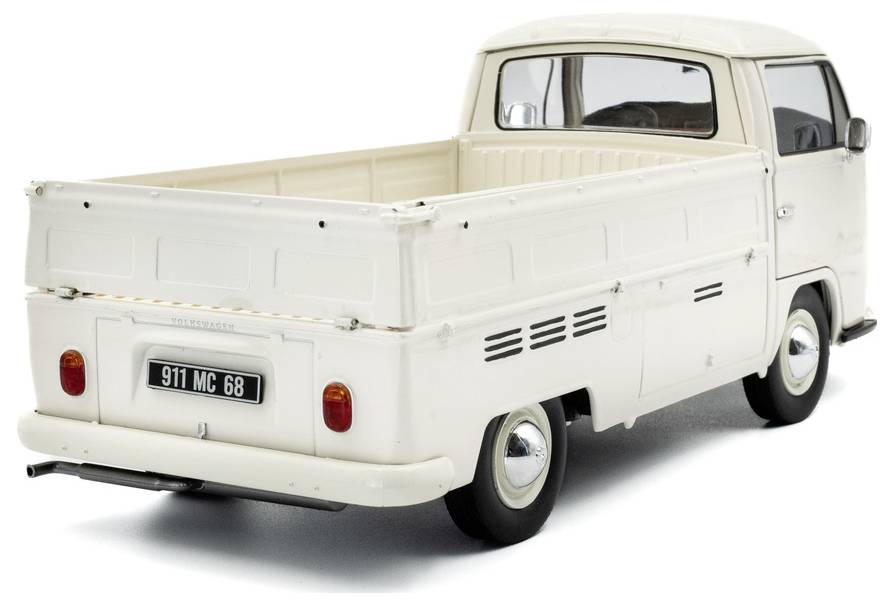 Z tyłu widać białą zabytkową ciężarówkę pickup, prezentującą klasyczny design, z tablicą rejestracyjną o numerze '911 MC 68'.