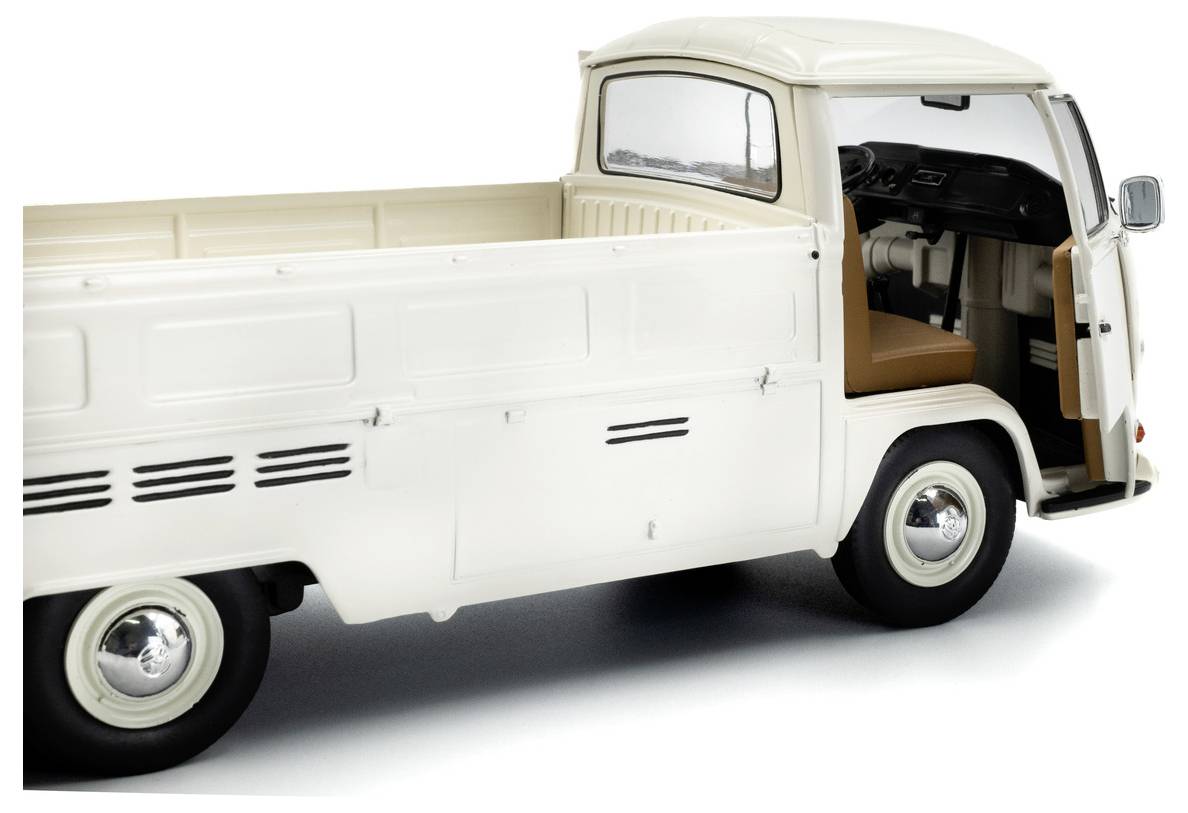 Biała zabytkowa ciężarówka z przedłużoną skrzyniąładunkową i brązowym wnętrzem, sfotografowana z boku, prezentująca retro design i gładkie linie.