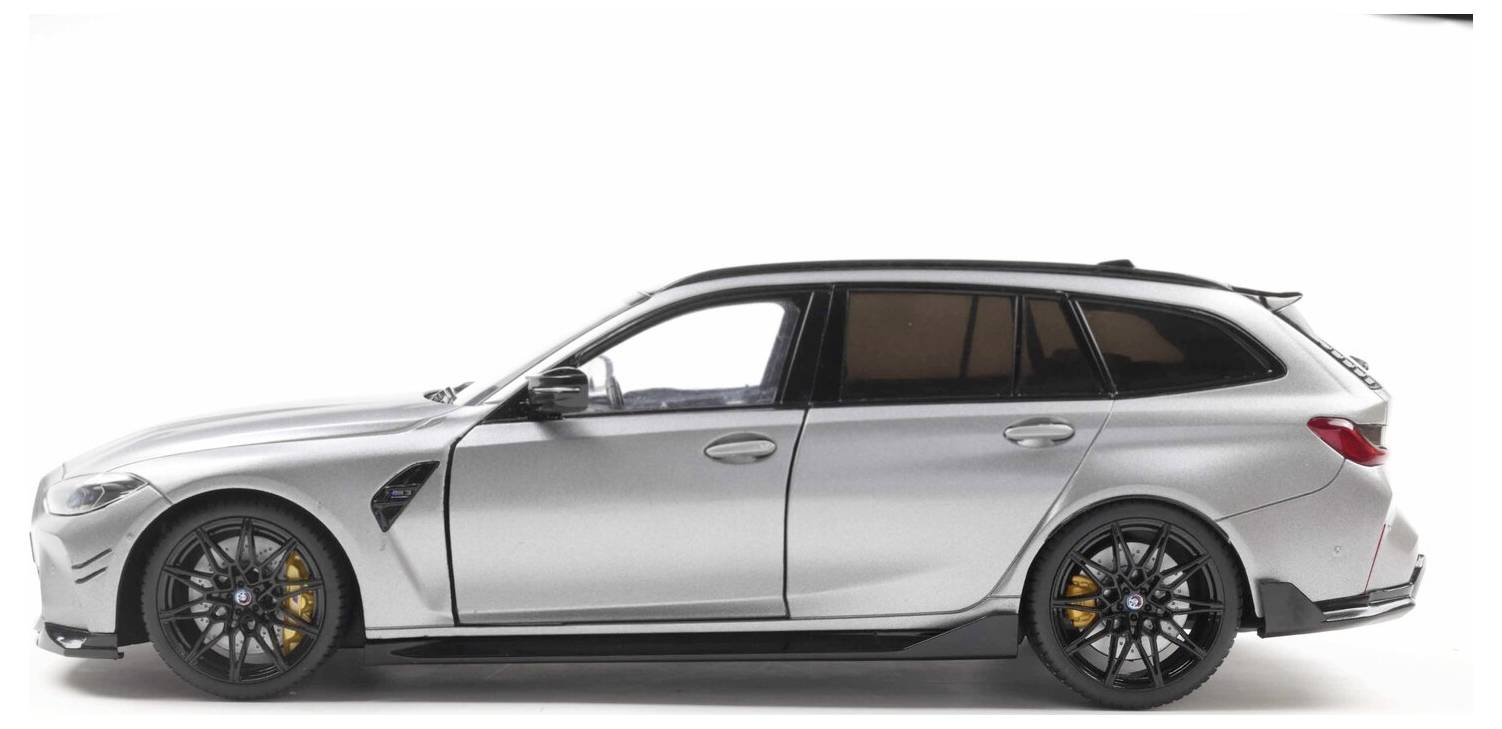 Smukły, srebrny samochód kombi z czarnymi kołami, prezentujący sportowy design. Pojazd jest ustawiony profilem na jednolitym tle.