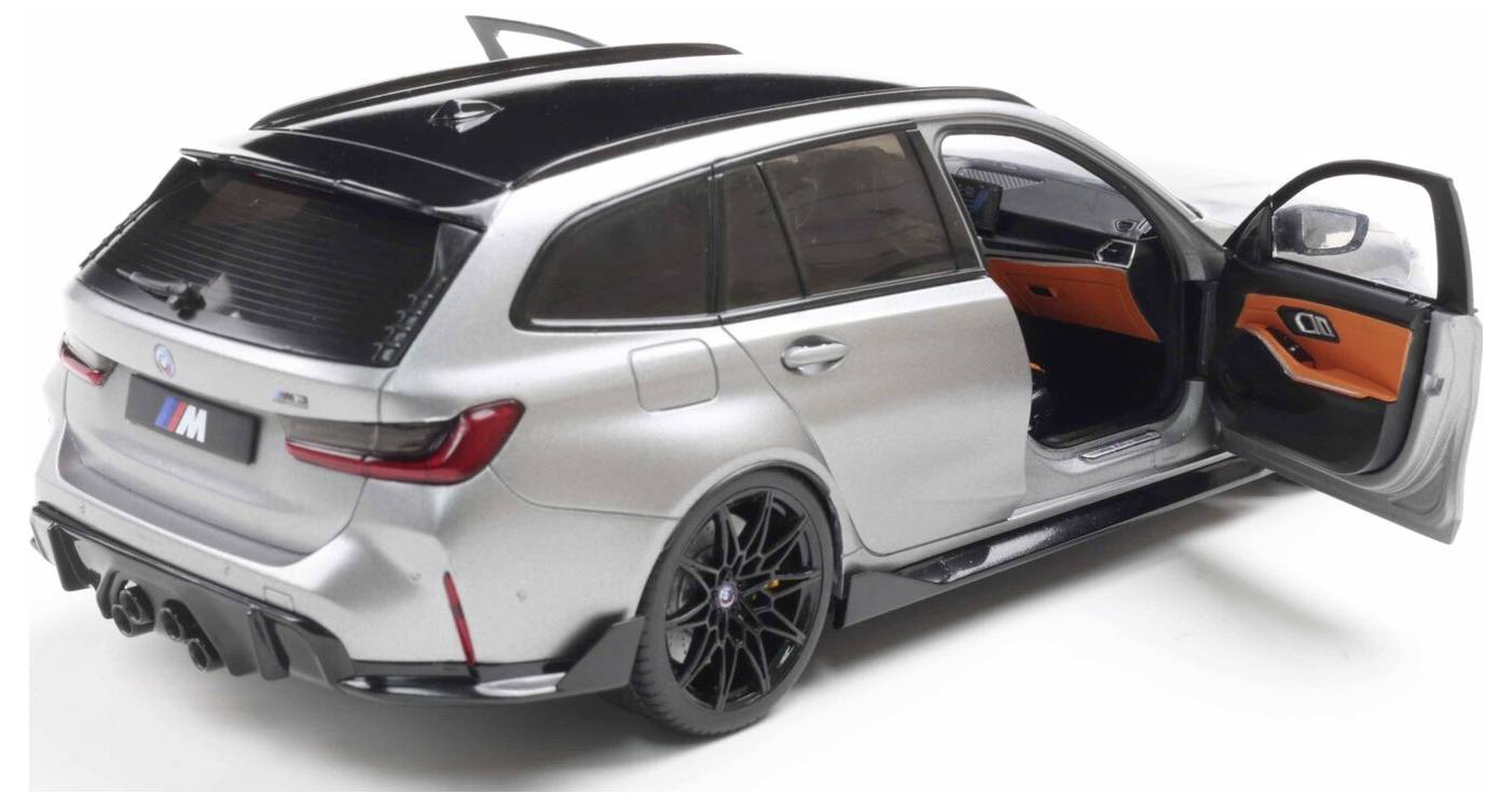 Srebrny model samochodu sportowego z czarnymi akcentami, z otwartymi drzwiami kierowcy i tylnymi drzwiami pasażerskimi. Wnętrze jest podświetlone na pomarańczowo.