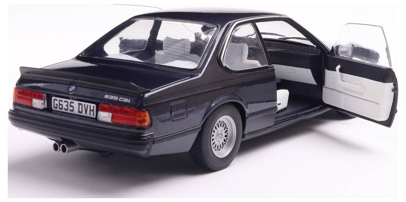 „Czarny samochód BMW z lat 80., z otwartymi drzwiami pasażera, ukazujący wnętrze pojazdu."