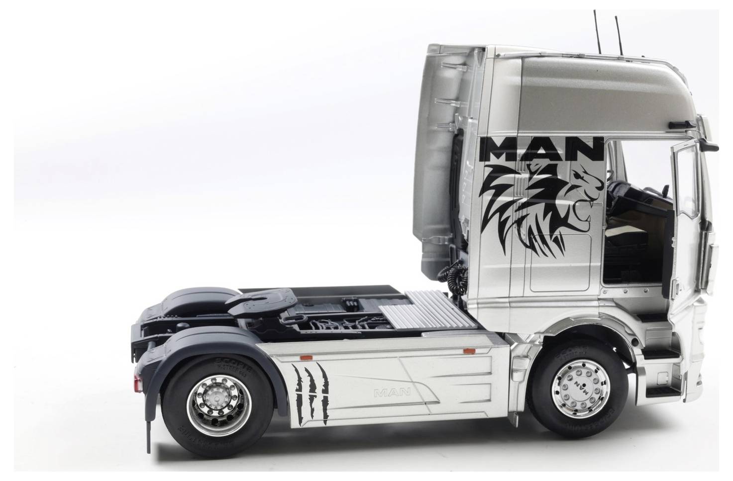 Srebrna kabina ciężarówki marki MAN z grafiką lwa po lewej stronie, oglądana z lewej perspektywy. Projekt podkreśla siłę i styl.