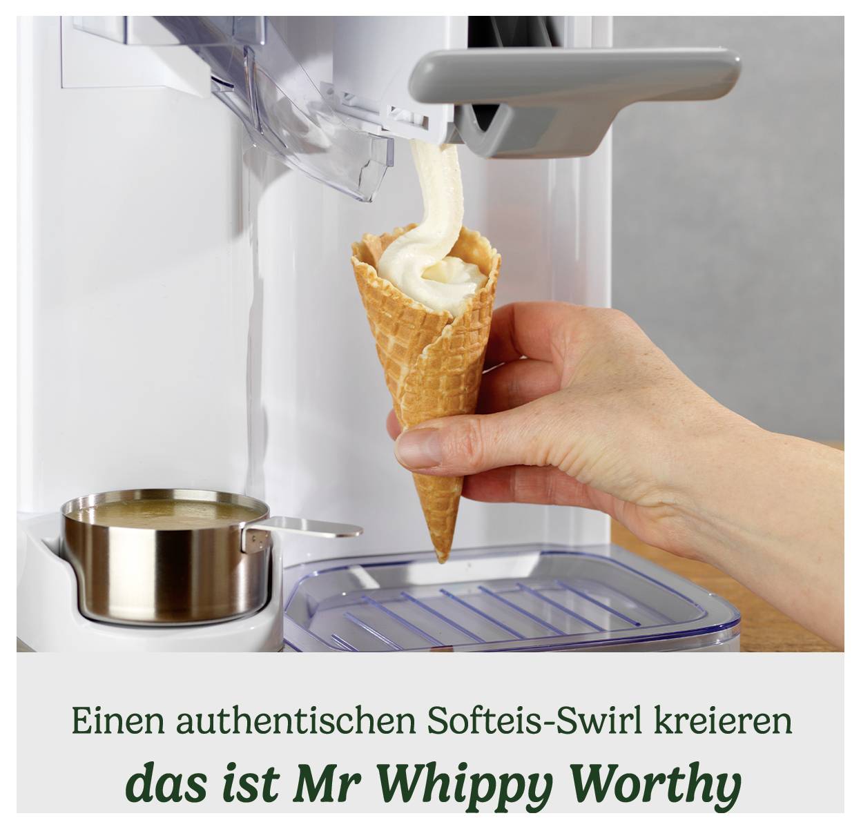 Ręka trzyma rożek pod dozownikiem napełniającym go miękkim lodem. Tekst brzmi: 'Stwórz autentyczny swirl softserve, oto jest godne Mr Whippy'.