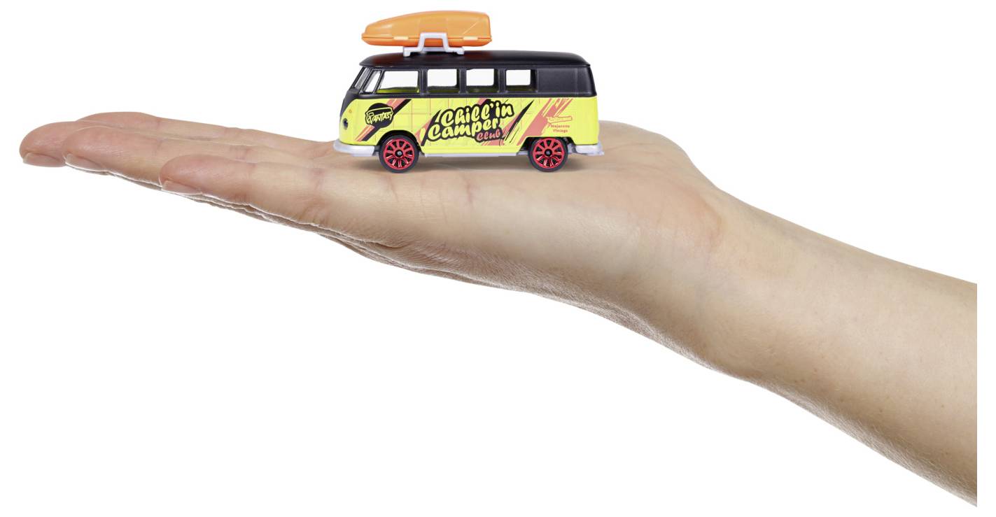 Ręka trzyma zabawkowy samochód dostawczy z napisem "Pacific Combi" na boku, z czarnym dachem, żółtym nadwoziem, czerwonymi kołami i pomarańczową deską surfingową na wierzchu.
