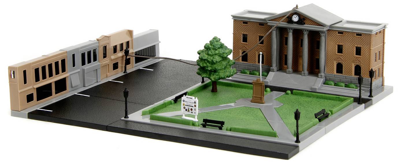 Miniaturowy model placu miejskiego z gmachem sądu ozdobionym kolumnami, zegarem, drzewem, otaczającymi budynkami i wybrukowaną drogą.