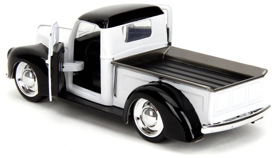 Odlewany model zabytkowego samochodu pickup z białym nadwoziem, czarnymi błotnikami i chromowanymi akcentami, sfotografowany z tyłu lewej strony z otwartymi drzwiami.