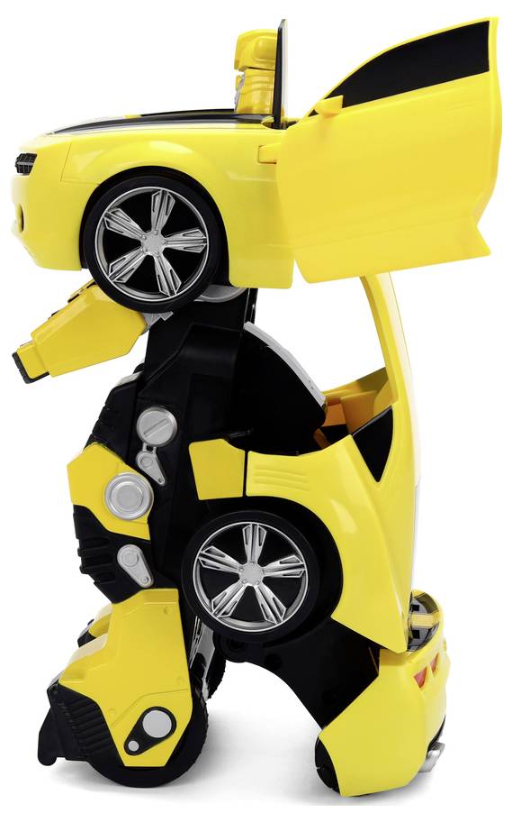 Żółty zabawkowy robot przekształca się w samochód, stojąc pionowo z otwartymi drzwiami i maską, ujawniając srebrne koła i szczegóły mechaniczne.