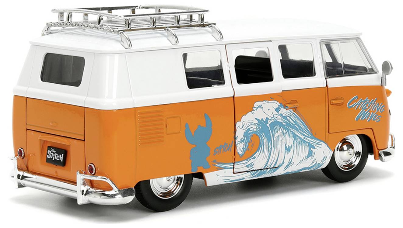 Pomarańczowo-biały zabytkowy van z grafiką surfingową i napisem 'Catching Waves' na boku, wyposażony w bagażnik dachowy i lśniące chromowane detale.