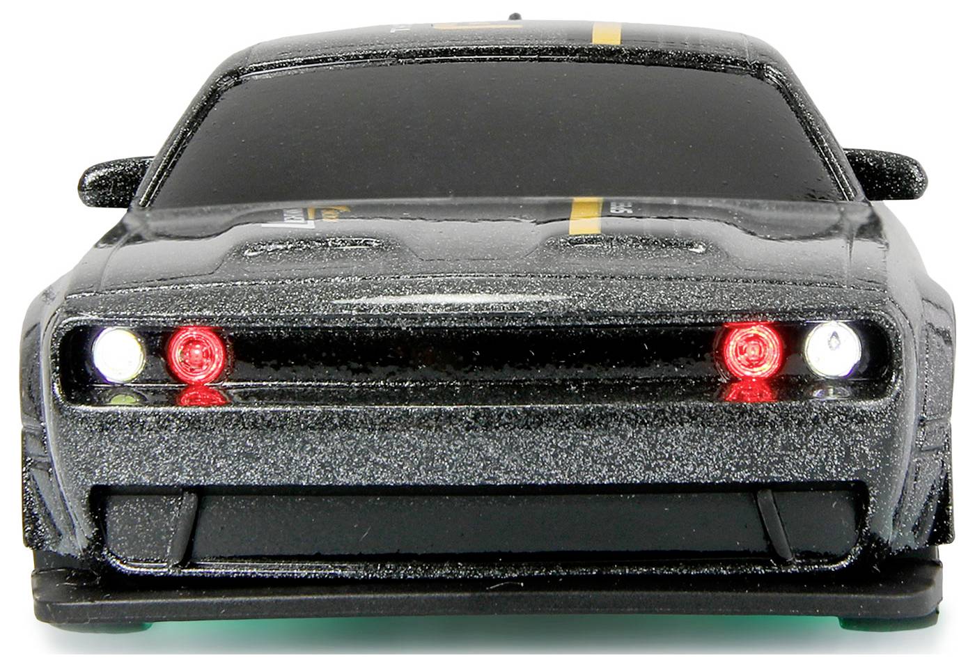 Czarny samochodzik zabawkowy z świecącymi na czerwono reflektorami, widziany od przodu, na białym tle.