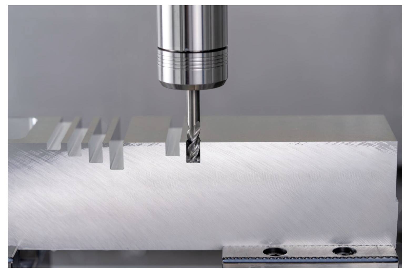 Narzędzie skrawające wykonuje rowki w bloku aluminium, demonstrując precyzyjne inżynieria w kontrolowanym środowisku.