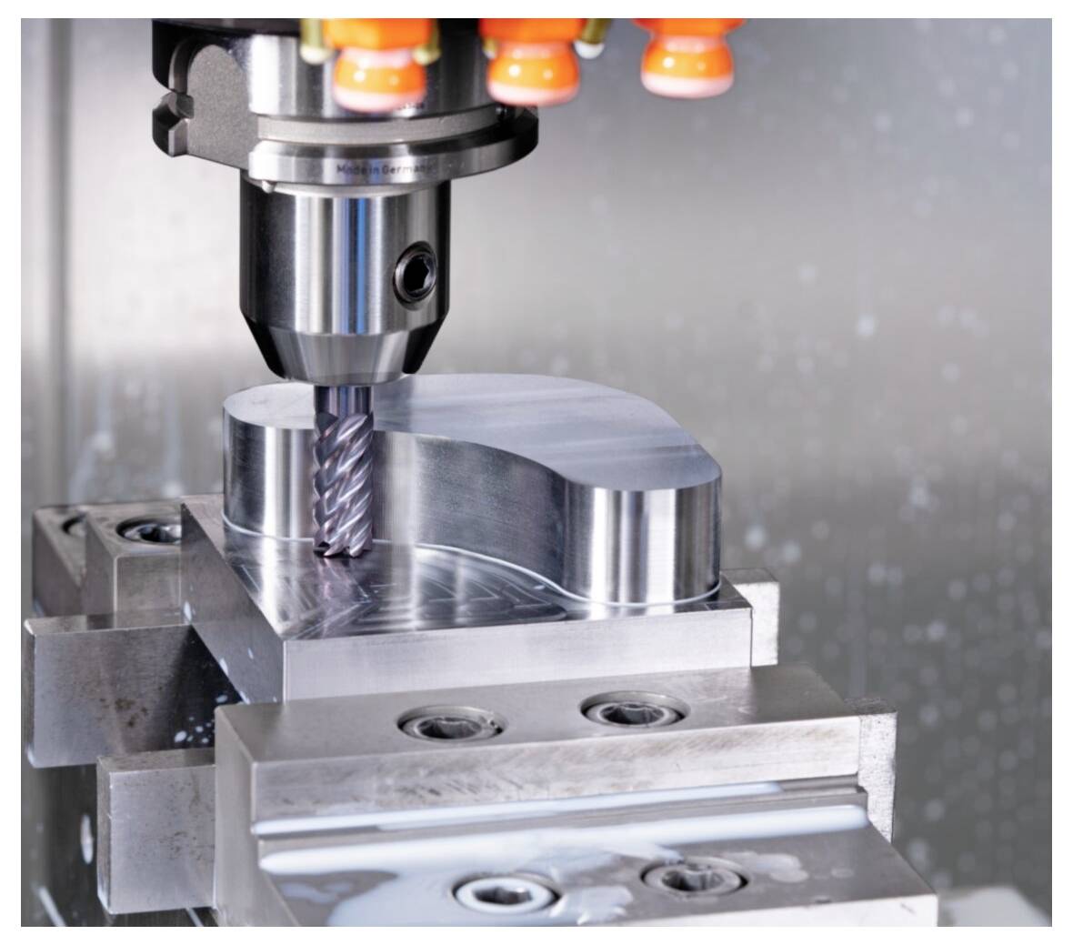 Zbliżenie maszyny CNC frezującej element metalowy, prezentujące precyzyjne inżynierystwo i przemysłowe procesy produkcyjne.