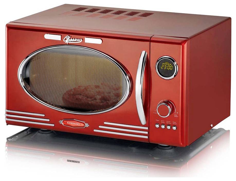 Czerwony, stylizowany na retro mikrofalowy piekarnik z cyfrowym wyświetlaczem zegara pokazującym '23:00', okrągłymi drzwiczkami oraz wieloma przyciskami sterowania.
