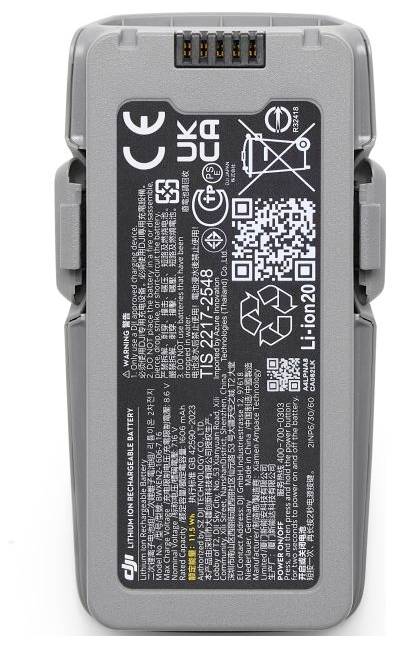 Szary akumulator litowo-jonowy z etykietami certyfikacyjnymi, ikoną recyklingu, kodem QR oraz instrukcjami użycia wydrukowanymi w kilku językach.
