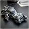 Model LEGO czarnego Batmobilu z figurką Batmana, umieszczony na ciemnym stole obok papierów. Batmobil ma charakterystyczne kątowe cechy projektu.