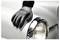 Rękawiczka ręka poleruje białą zewnętrzną powierzchnię zabytkowego samochodu w pobliżu reflektora, podkreślając błyszczący i dobrze utrzymany stan pojazdu.