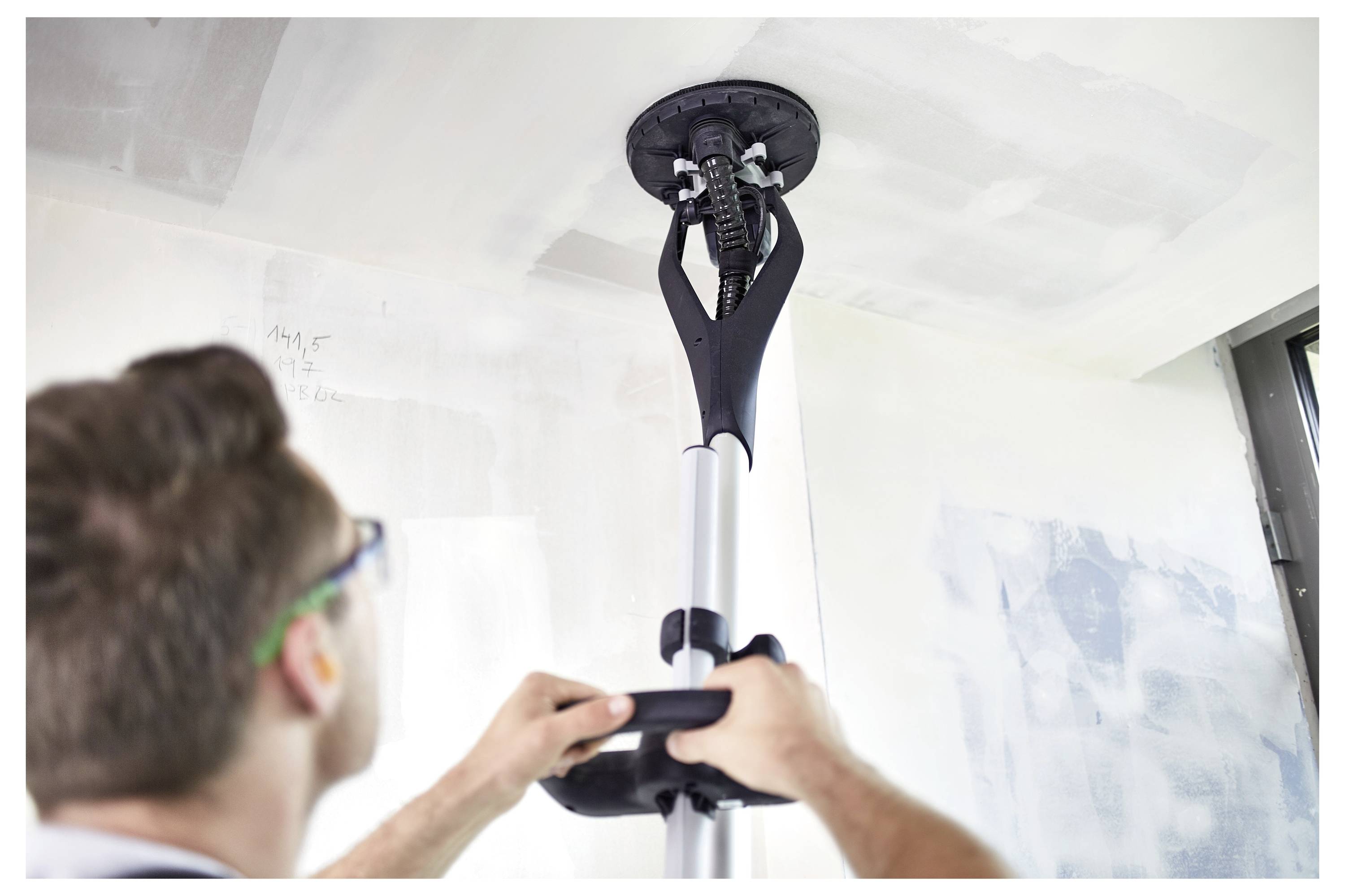 Zamontowana, oświetlona lampa robocza jest przymocowana do drewnianego belki w otoczeniu budowy, zapewniając skoncentrowane oświetlenie do wykonywania zadań.