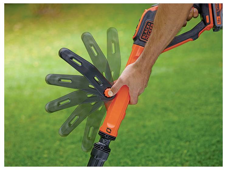 Ręka reguluje kąt narzędzia do trawy BLACK+DECKER z pomarańczowym uchwytem i wieloma pozycjami ostrzy, umieszczonego na zielonej trawniku.