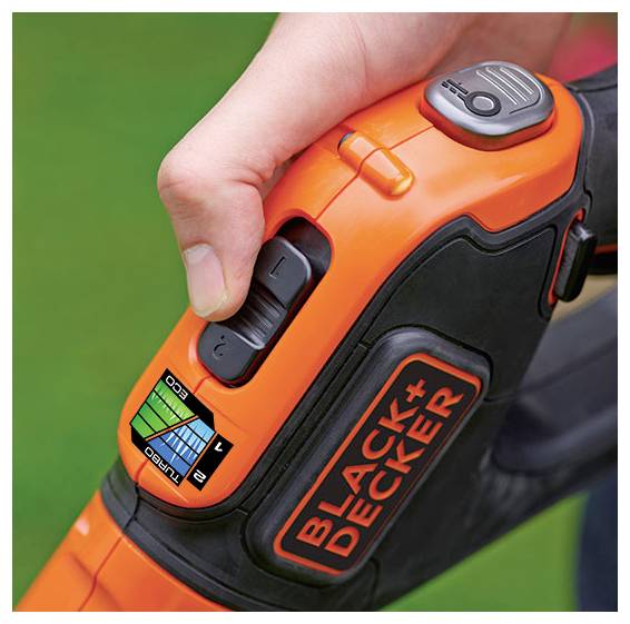 Ręka osoby reguluje pokrętło prędkości na pomarańczowej bezprzewodowej dmuchawce do liści Black+Decker, wyposażonej w cyfrowy wskaźnik poziomu naładowania baterii.