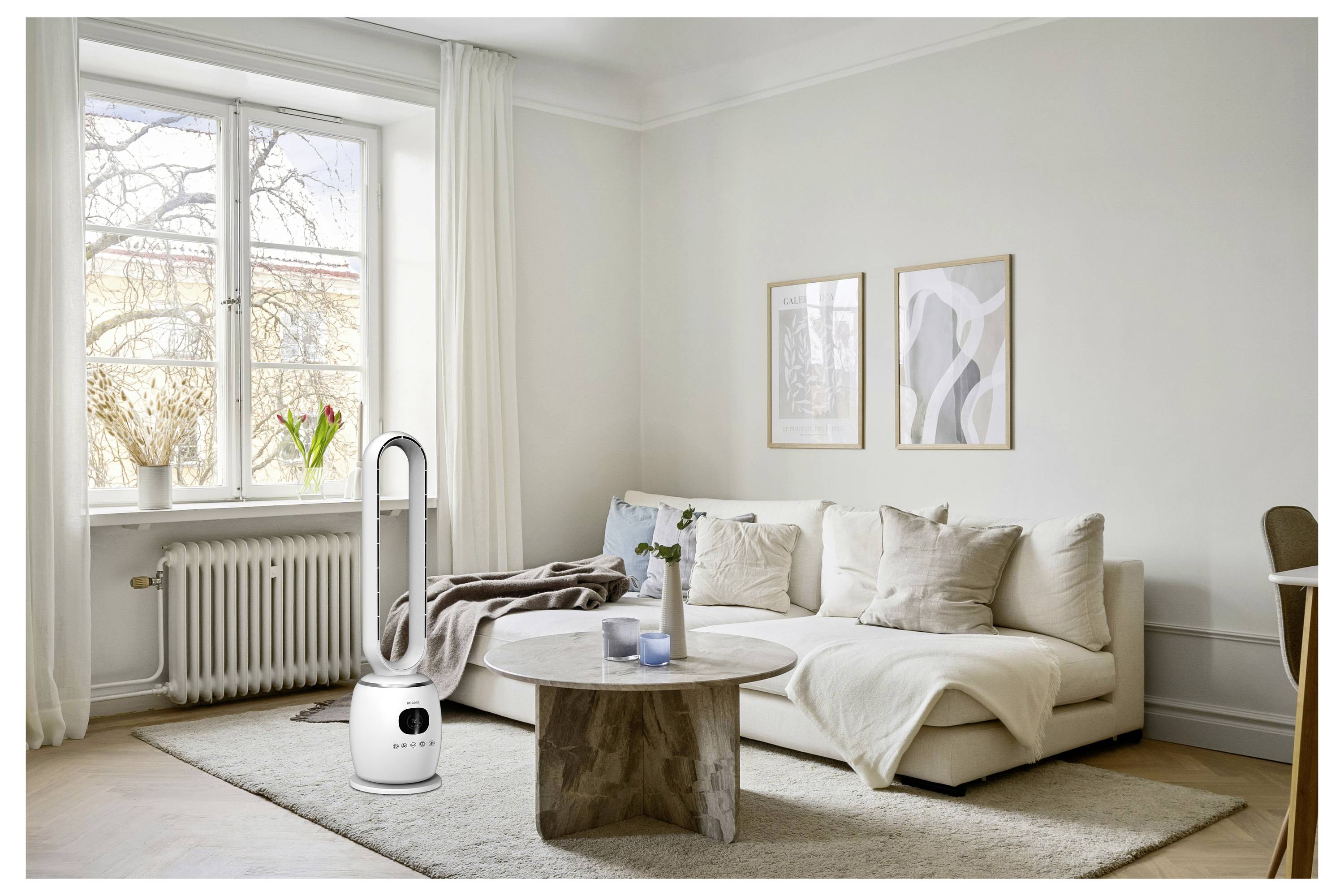 Nowoczesny salon z białą sofą, okrągłym drewnianym stolikiem kawowym i dużym oknem. Wysoki, elegancki oczyszczacz powietrza stoi obok sofy.