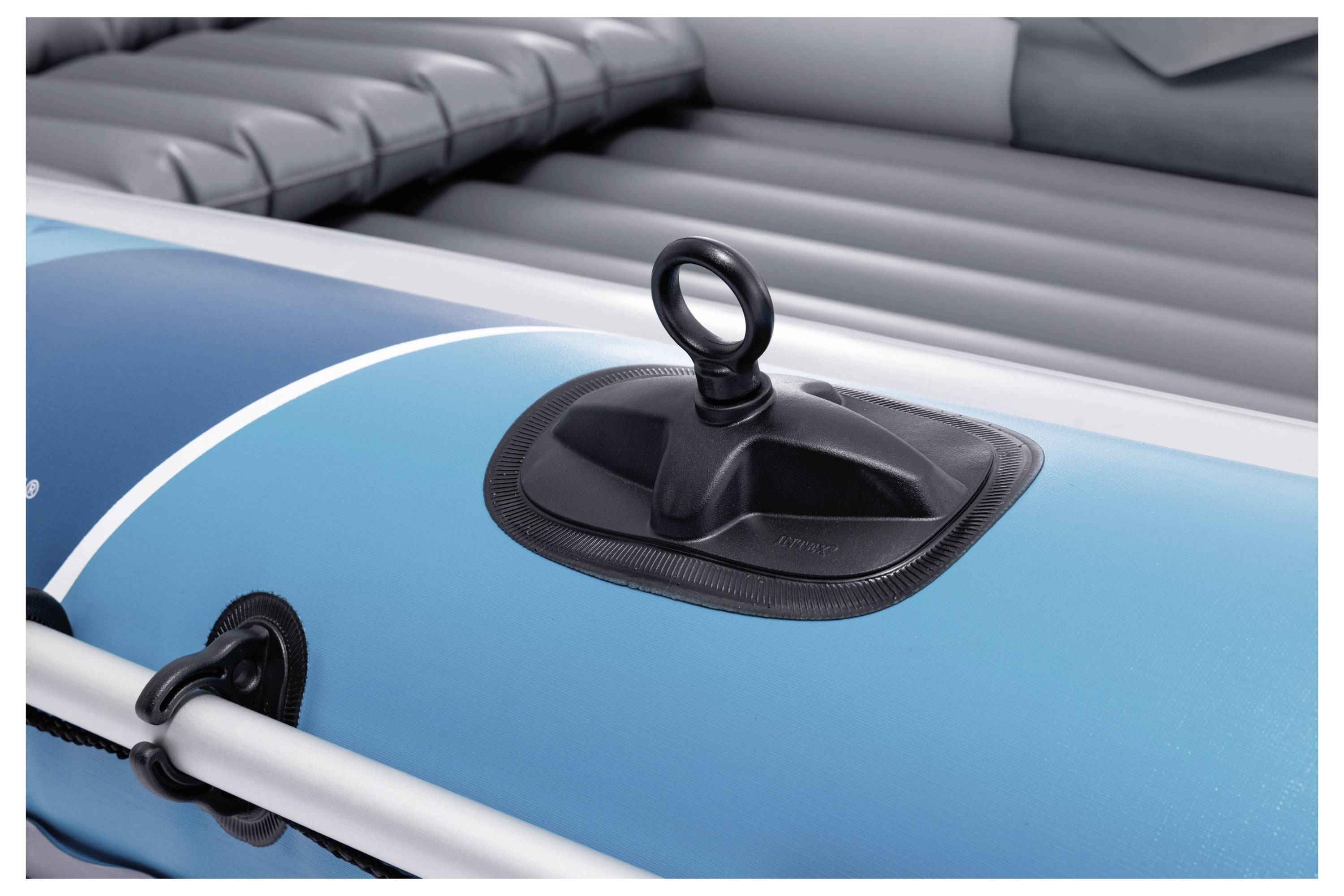 Zbliżenie niebieskiej łodzi pneumatycznej z przymocowanym czarnym pierścieniem z boku, pokazujące szczegóły konstrukcji i materiałów łodzi.