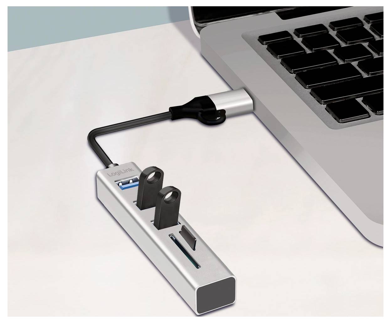 Hub USB podłączony do laptopa, pokazujący pendrive i inne urządzenia wpięte w adapter