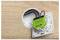 Zielony inteligentny wyłącznik z przewodami jest częściowo włożony do gniazda ściennego przy drewnianej powierzchni, demonstrując instalację automatyki domowej.