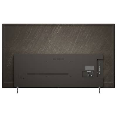 Widok z tyłu telewizora LG OLED na stojaku, pokazujący tylny panel, porty i osłonę kabli na tle ciemnej ściany.