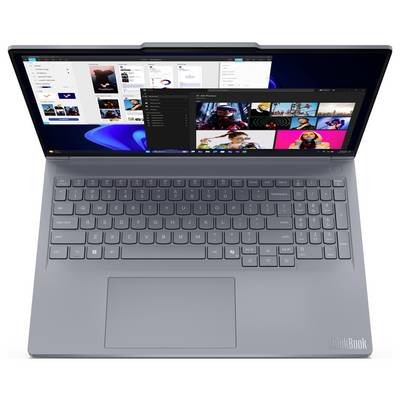 Laptop otwarty widziany z góry, pokazujący pulpit systemu Windows i nakładające się okna aplikacji na ekranie.