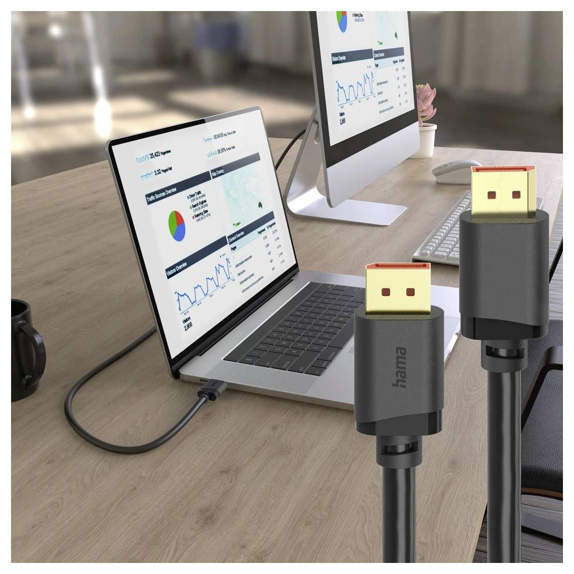 Laptop i monitor stacjonarny wyświetlające pulpity analityki na biurku, połączone kablami HDMI.