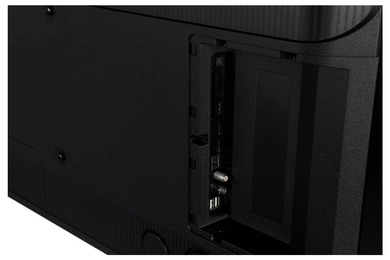 Widok tylny telewizora pokazujący zagłębione porty i panel wejściowy, w tym połączenia HDMI i USB, w czarnej obudowie.