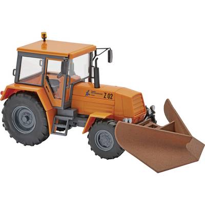 Pomarańczowy traktor ładowacz z przodu z dużym zasobnikiem na białym tle.