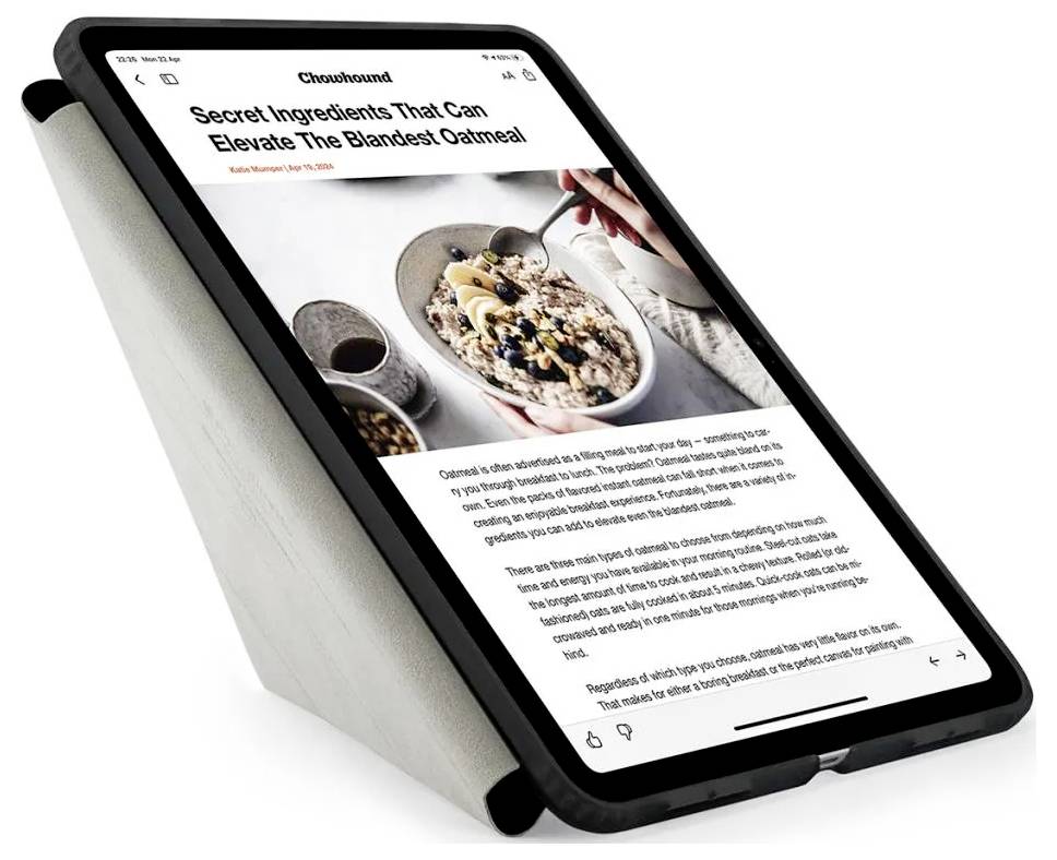 Tablet wyświetlający artykuł z Good Housekeeping zatytułowany „Tajne Składniki, Które Potrafią Podnieść Najbrzydszy Owsiankę" ze zdjęciem miski owsianki, do której ręka dodaje dodatki.
