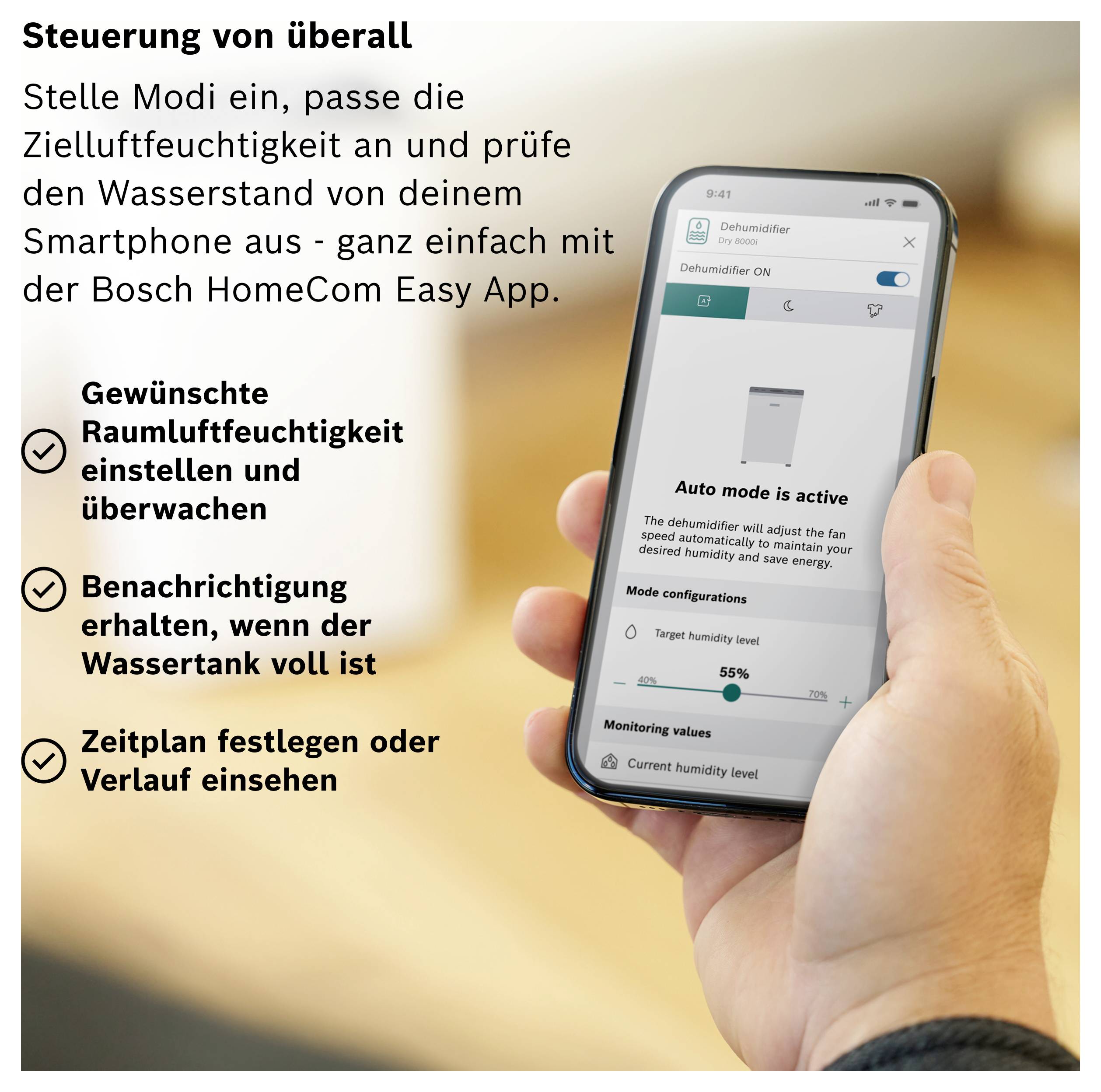 Ilustracja reklamowa: Dłoń trzyma smartfon z aplikacją Bosch HomeCom Easy do sterowania osuszaczem powietrza; po lewej stronie znajdują się funkcje umożliwiające kontrolę wilgotności powietrza, poziomu wody i harmonogramu.