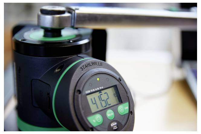 Elektroniczny klucz dynamometryczny z cyfrowym wyświetlaczem pokazującym 416.2, podłączony do metalowego złącza do precyzyjnego dokręcania.