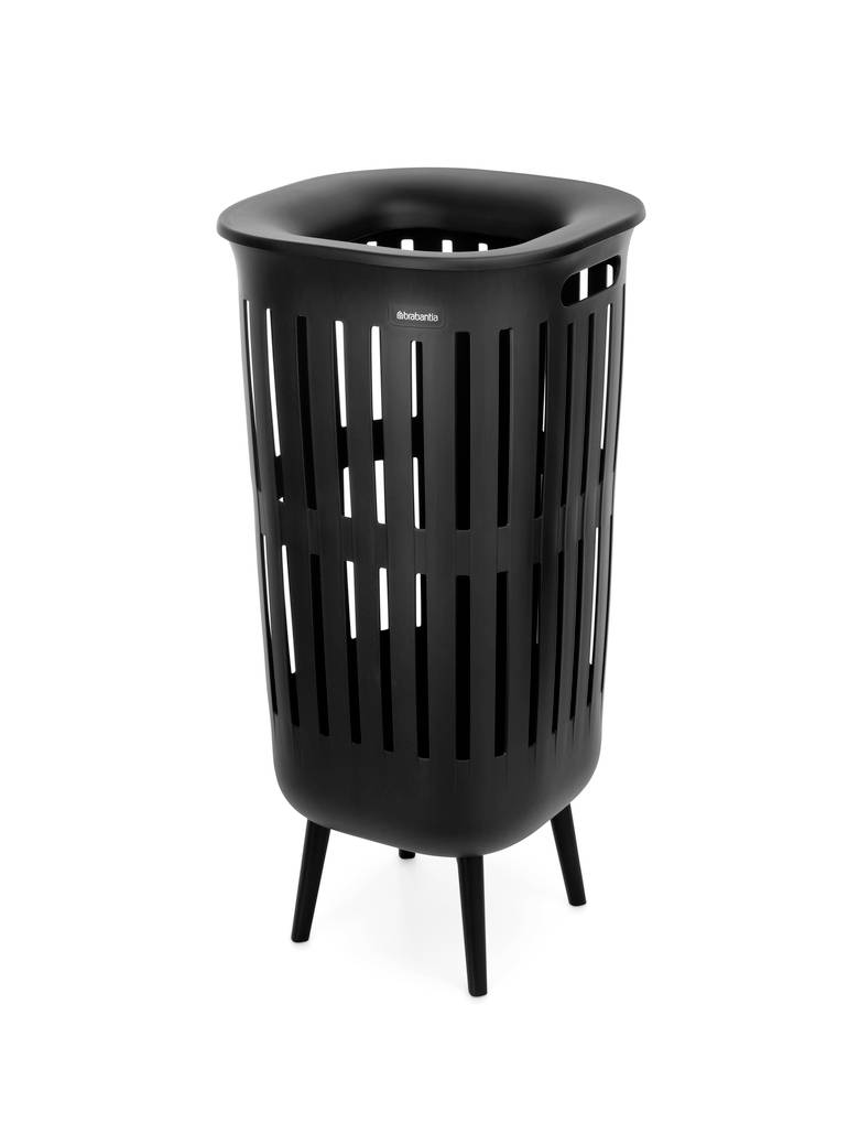 Czarna śmietnika lub koszyka z listwami, w kształcie cylindrycznym, na czterech nogach, pokazana na białym tle.
