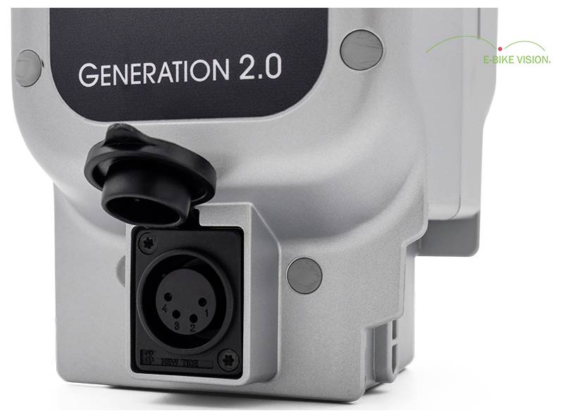 Zbliżenie srebrnego urządzenia oznakowanego 'GENERATION 2.0' z okrągłym portem łącznika i logiem E-BIKE VISION.