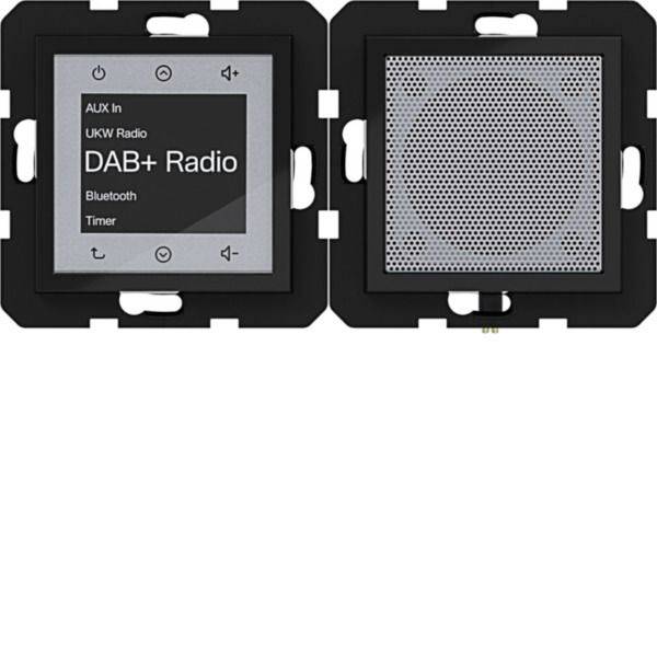Dwie czarne głośniki montowane na ścianie, jeden z ekranem dotykowym oznaczonym „DAB+ Radio", „UKW Radio", „Bluetooth" i „Timer", drugi z perforowaną kratką głośnika.