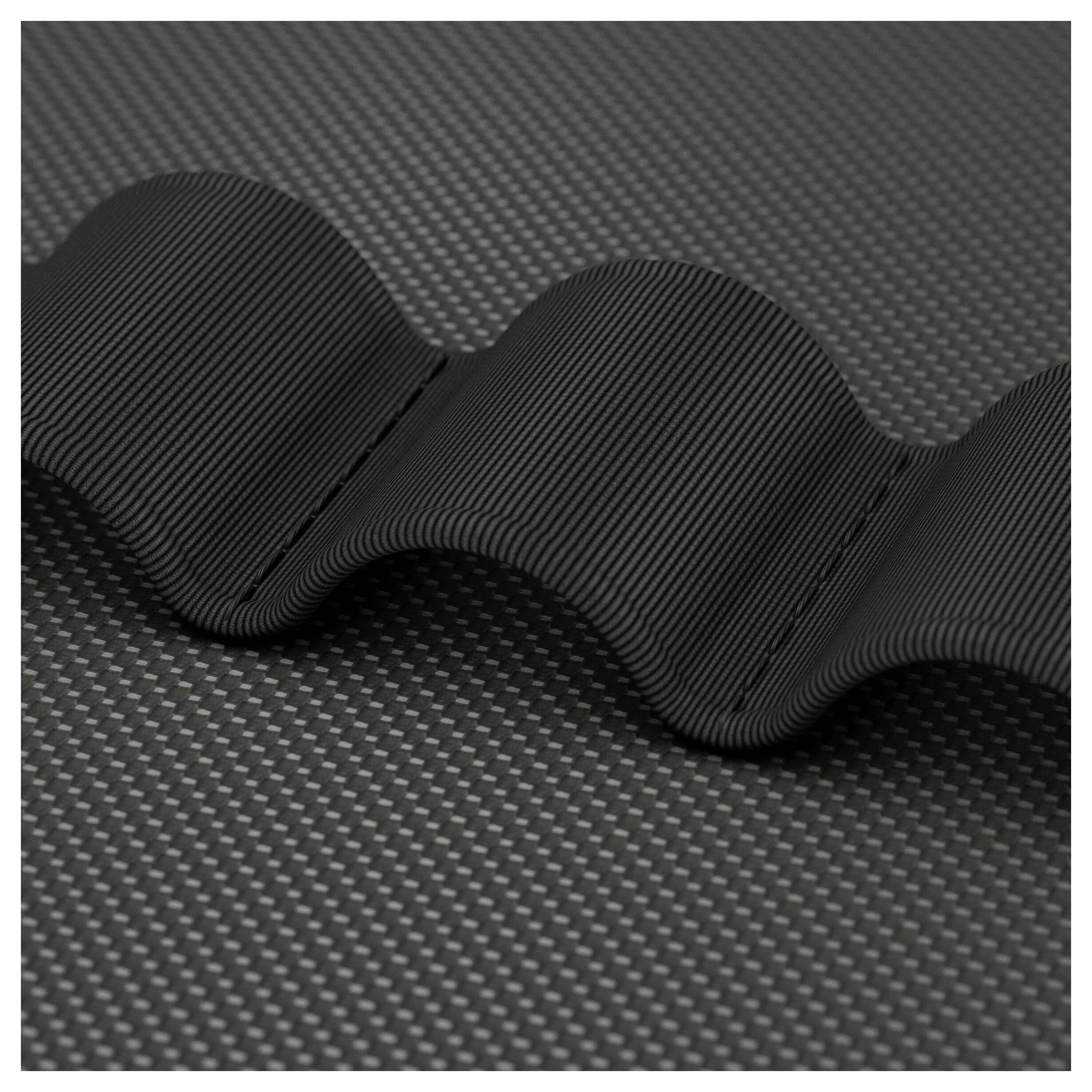 Czarna falista, prążkowana taśma lub pasek leżący na szarej teksturowanej powierzchni, pokazany w zbliżeniu.