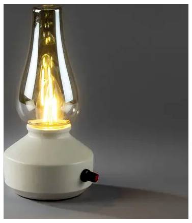 Zapalona elektryczna lampa olejowa z przezroczystym szkllanym kominem i małym czarno-czerwonym pokrętłem sterowania na szarym tle.