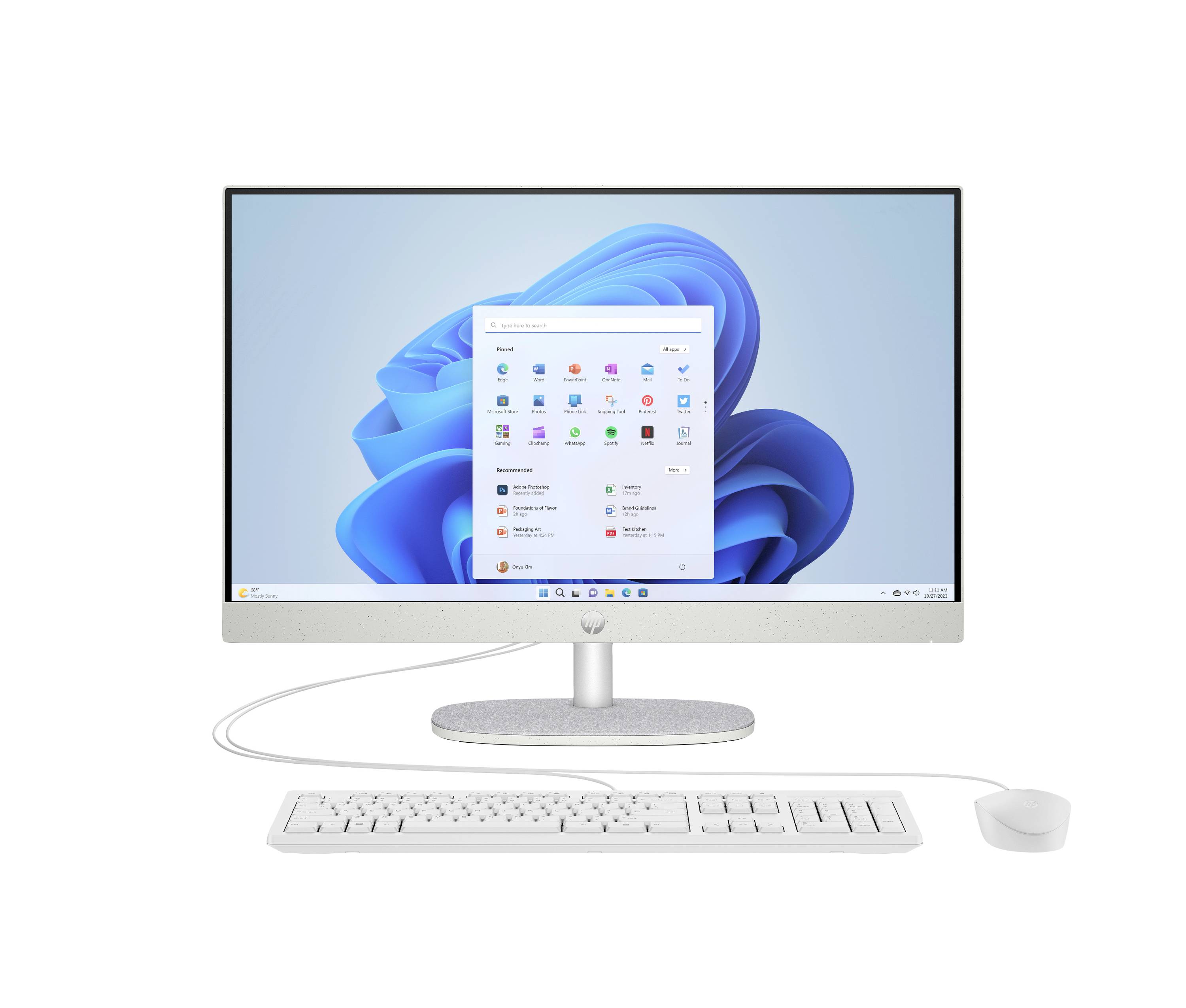 Komputer stacjonarny typu all-in-one z otwartym menu Start systemu Windows 11, pokazujący monitor, klawiaturę i mysz na białym tle.