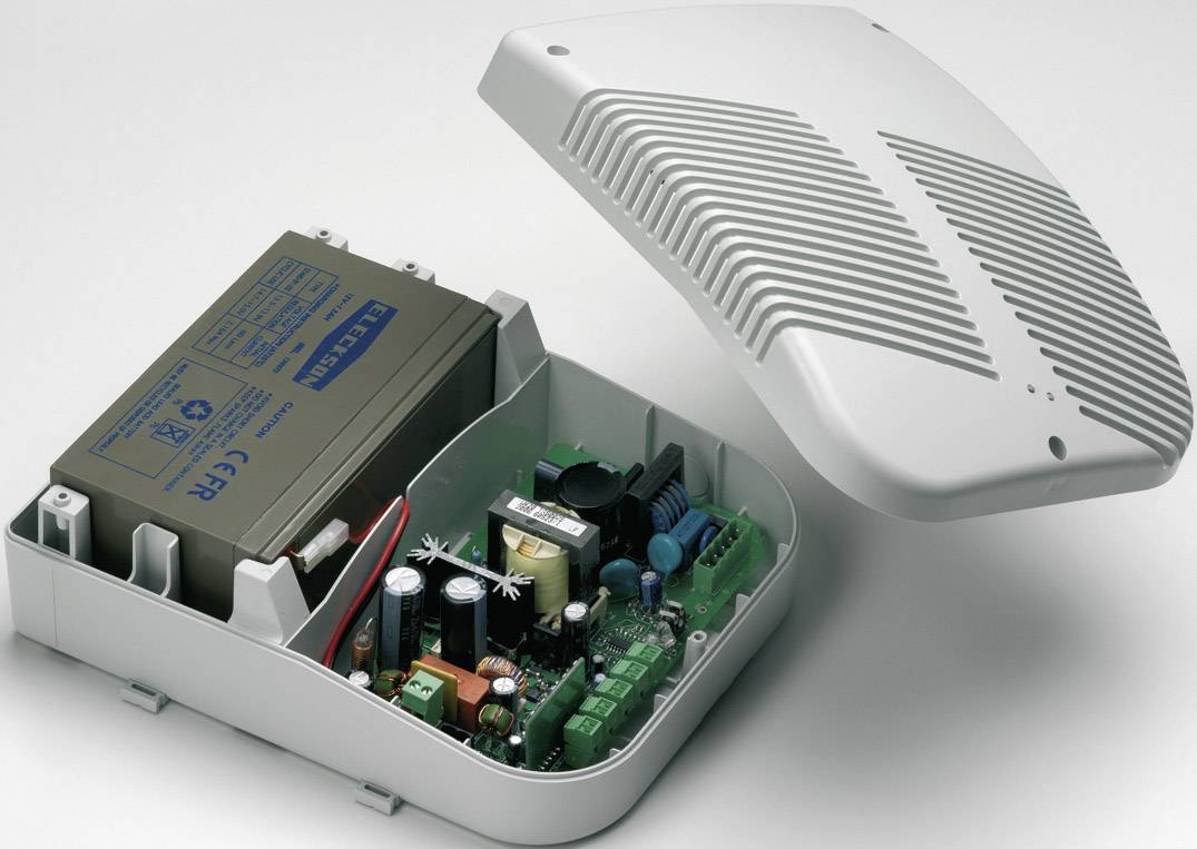 Otwarte pudełko obudowy z elektronicznym obwodem i baterią, prawdopodobnie element systemu bezpieczeństwa lub urządzenia elektrycznego.