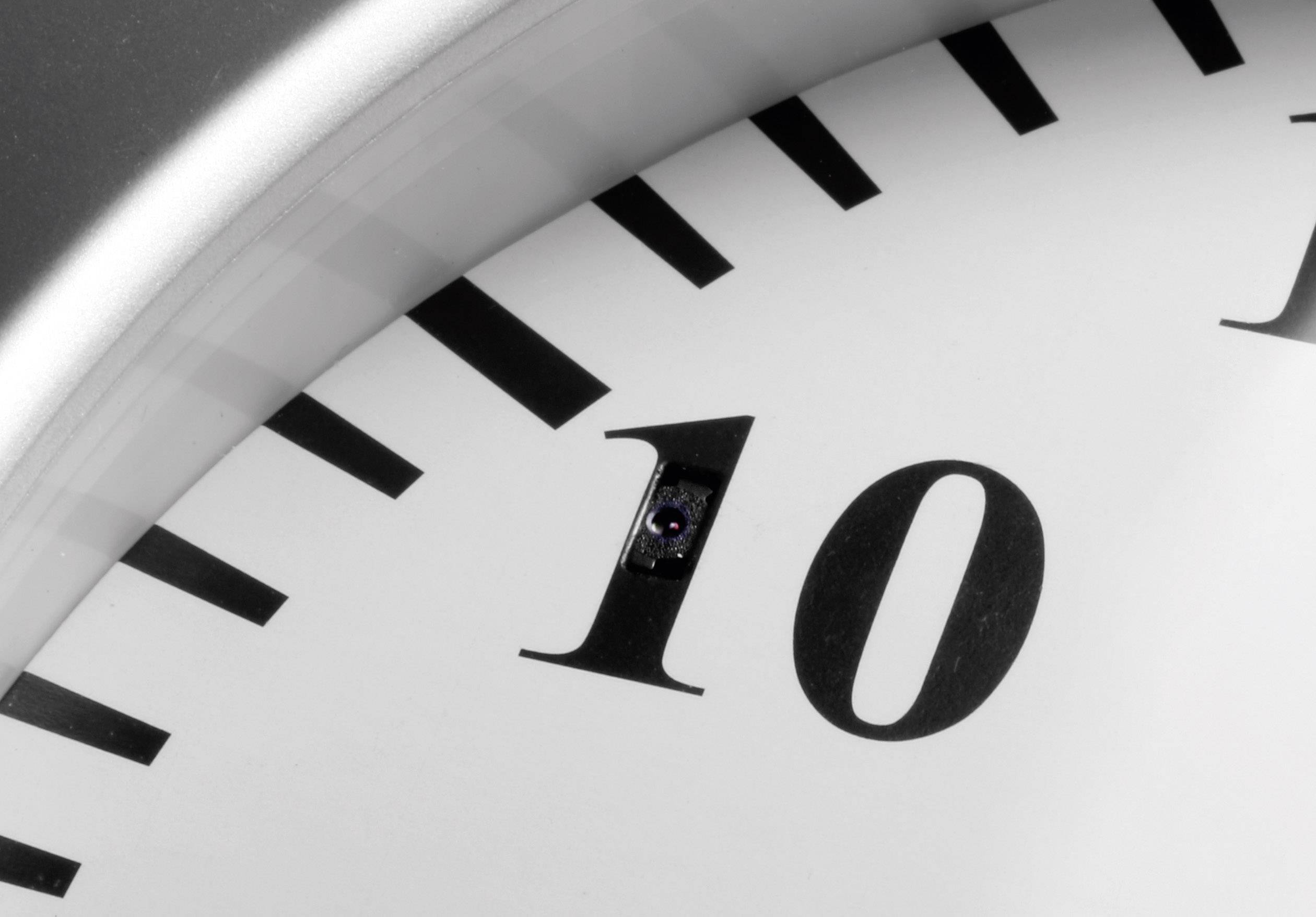 Zbliżenie analogowego zegara, z fokusem na cyfrę '10'. Wskazówki godzinowe i minutowe nie są widoczne.